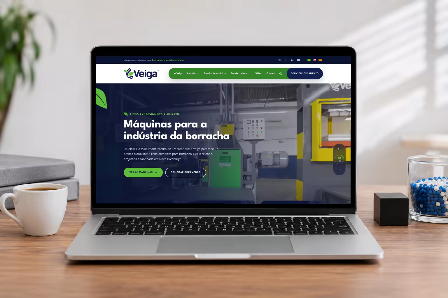 O site da Veiga Sul num notebook sobre a mesa, ao lado de um bloco de borracha preta e de um pote de grânulos de plástico reciclado
